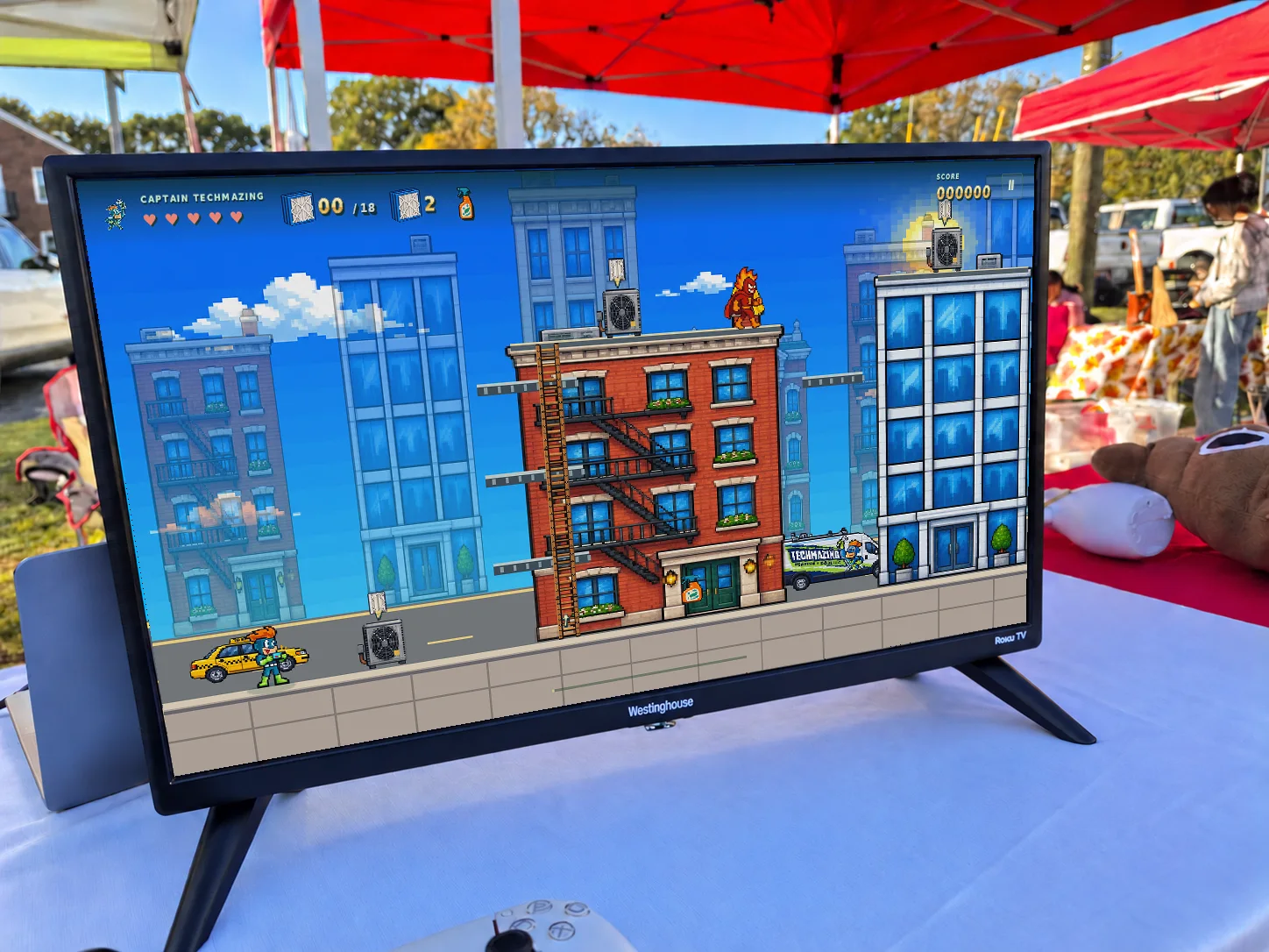 The Techmazing game’s city level displayed on a TV at AutumnFest